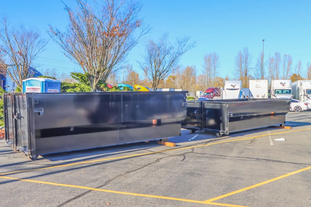 Professional dumpster rental service with roll-off container on residential driveway in River Road
